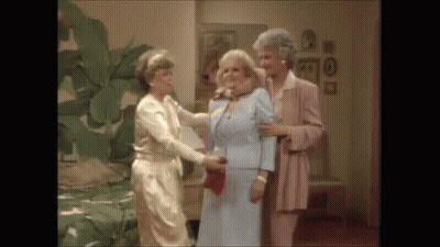 A Group Of Three Women Are Standing Next To Each Other In A Room . GIF