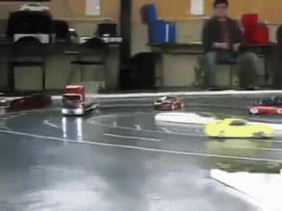 A Group Of Toy Cars Are Racing On A Track In A Room GIF
