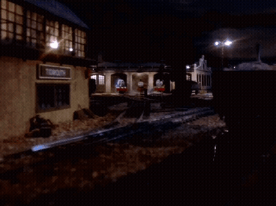 A Group Of Train Engines Are Parked In A Garage At Night GIF
