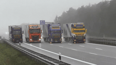 A Group Of Trucks Are Driving Down A Highway With A Sign That Says ' A / N ' On It GIF