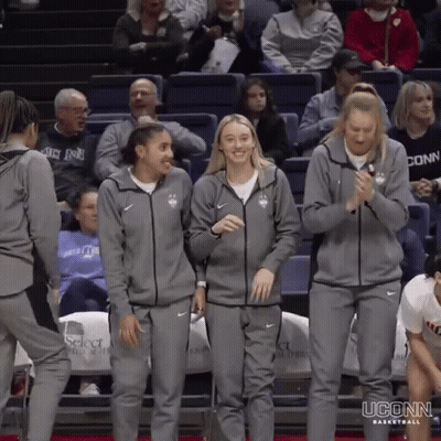 A Group Of Uconn Basketball Players Are Standing On The Court GIF