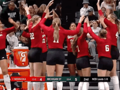A Group Of Volleyball Players Are Giving Each Other A High Five In Front Of A Crowd . GIF