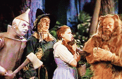A Group Of Wizard Of Oz Characters Are Standing Together GIF