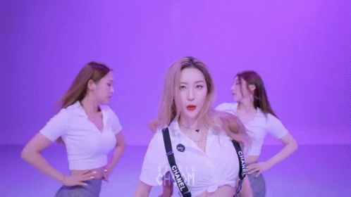 A Group Of Women Are Dancing And One Of Them Has Chanel Suspenders GIF