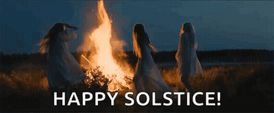 A Group Of Women Are Dancing Around A Fire In A Field At Night . GIF