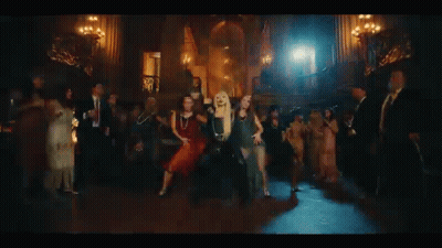 A Group Of Women Are Dancing In A Dark Room In Front Of A Castle . GIF