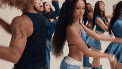 A Group Of Women Are Dancing In Blue Outfits With A Man In A Black Tank Top GIF