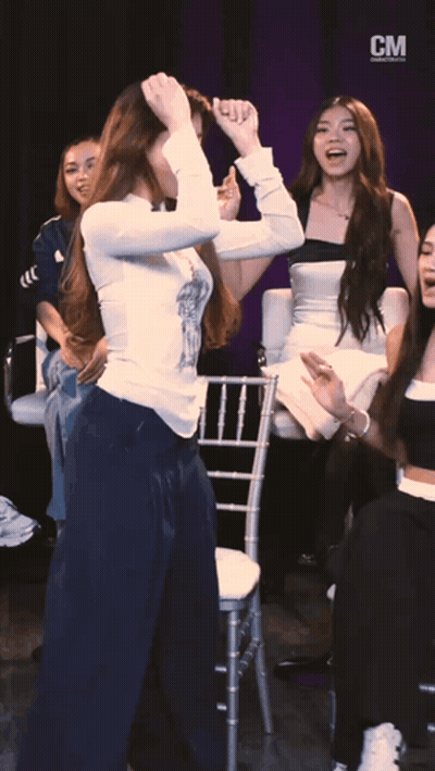 A Group Of Women Are Dancing In Front Of A Cm Banner GIF