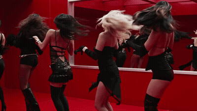 A Group Of Women Are Dancing In Front Of A Mirror In A Red Room GIF