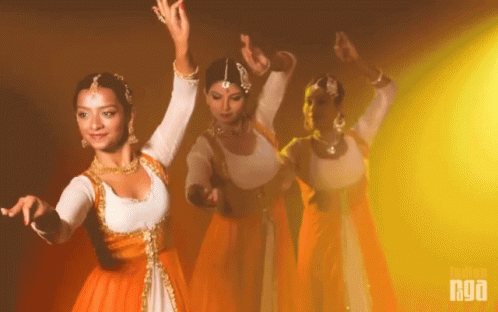A Group Of Women Are Dancing In Front Of A Yellow Background With The Word Nua On It GIF
