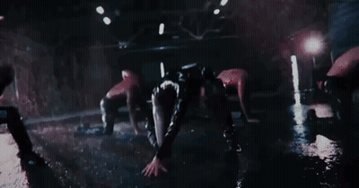 A Group Of Women Are Dancing In The Dark In A Dark Room . GIF