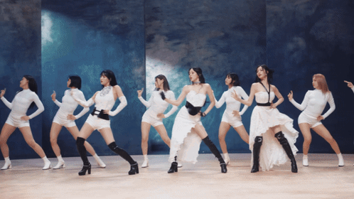 A Group Of Women Are Dancing In White Dresses GIF