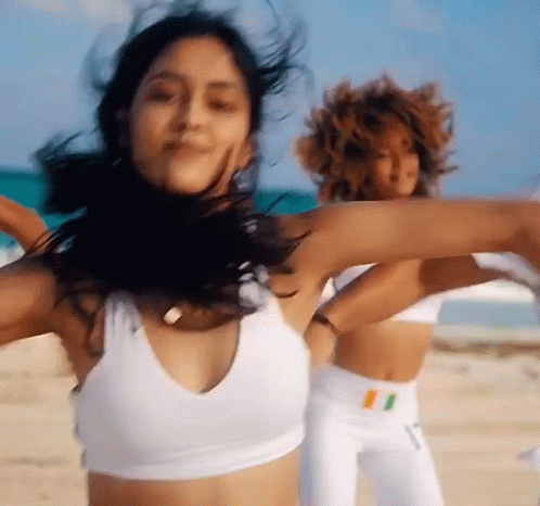 A Group Of Women Are Dancing On A Beach . GIF