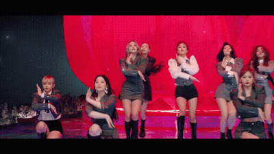 A Group Of Women Are Dancing On A Stage In Front Of A Red Wall . GIF