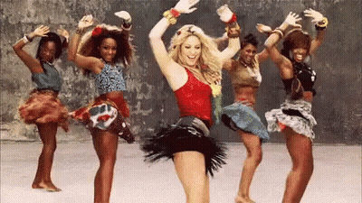 A Group Of Women Are Dancing Together And One Of Them Is Wearing A Red Tank Top . GIF