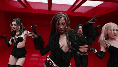 A Group Of Women Are Dancing Together In A Red Room GIF