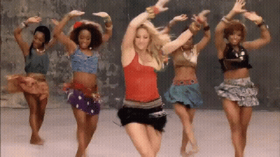 A Group Of Women Are Dancing Together In Front Of A Wall In A Room . GIF