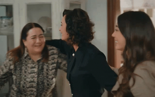 A Group Of Women Are Hugging Each Other And Laughing GIF