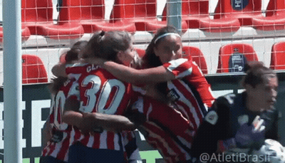 A Group Of Women Are Hugging Each Other On A Soccer Field . One Of The Players Has The Number 30 On Her Jersey . GIF