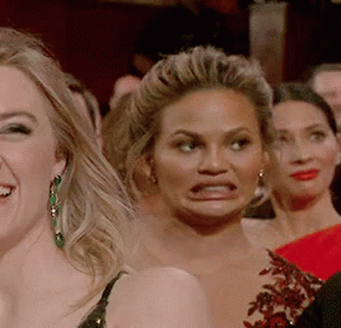 A Group Of Women Are Making Funny Faces In A Crowd . GIF