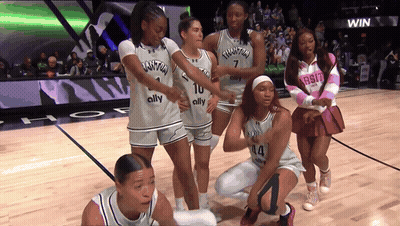 A Group Of Women Are On A Basketball Court Wearing Jerseys That Say Quantum GIF