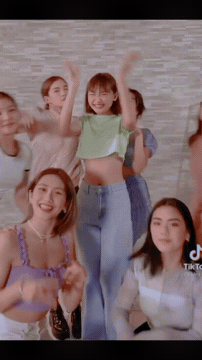 A Group Of Women Are Posing For A Picture And One Of Them Has A Green Shirt On GIF