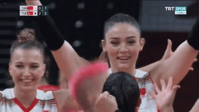 A Group Of Women Are Raising Their Hands In The Air During A Game . GIF