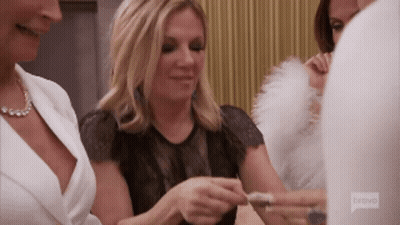 A Group Of Women Are Sitting Around A Table And One Of Them Is Wearing A Bravo Shirt GIF