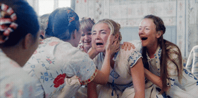 A Group Of Women Are Sitting Around A Woman Who Is Crying And Laughing . GIF