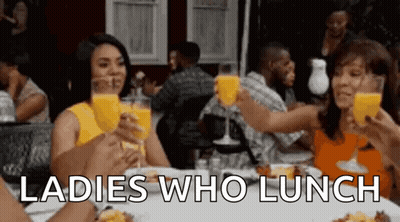 A Group Of Women Are Sitting At A Table Drinking Orange Juice And Toasting . GIF