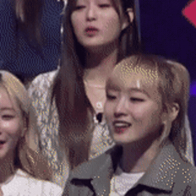 A Group Of Women Are Sitting In A Row And One Of Them Is Looking At The Camera . GIF