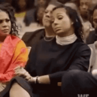 A Group Of Women Are Sitting In A Stadium Watching A Game . GIF
