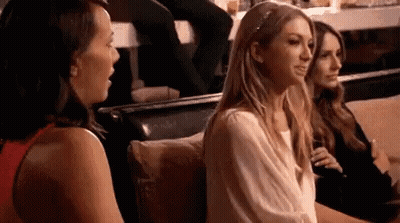 A Group Of Women Are Sitting On A Couch Talking To Each Other In A Restaurant . GIF