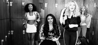 A Group Of Women Are Standing In A Locker Room Dancing . GIF