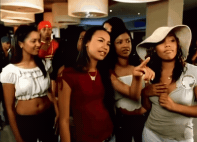 A Group Of Women Are Standing In A Room And One Woman Is Pointing At Something GIF