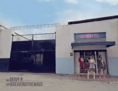 A Group Of Women Are Standing In Front Of A Queen Tv Building GIF