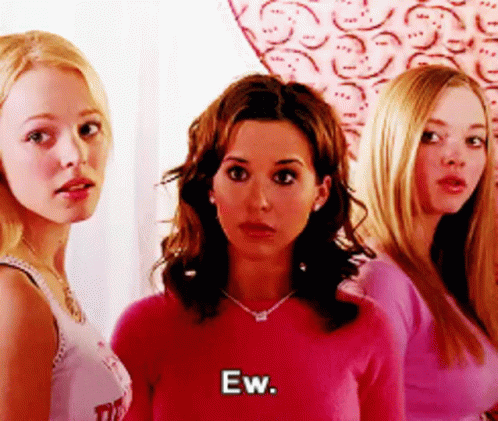 A Group Of Women Are Standing Next To Each Other And One Of Them Is Wearing A Pink Sweater And Says Ew . GIF