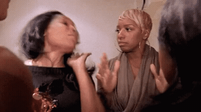 A Group Of Women Are Standing Next To Each Other Having A Conversation . GIF