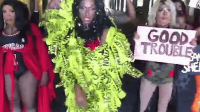 A Group Of Women Are Standing Next To Each Other Holding Signs That Say Good Trouble . GIF