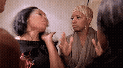 A Group Of Women Are Standing Next To Each Other In A Room . GIF