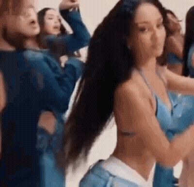 A Group Of Women Are Standing Next To Each Other In A Room . GIF
