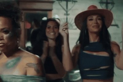 A Group Of Women Are Standing Next To Each Other In A Room . GIF