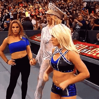 A Group Of Women Are Standing Next To Each Other In A Wrestling Ring . GIF