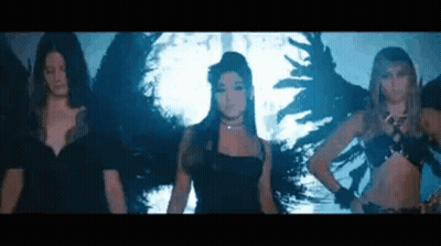 A Group Of Women Are Standing Next To Each Other In Front Of A Wall With Wings On It . GIF