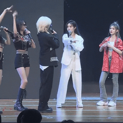 A Group Of Women Are Standing On A Stage Holding Microphones GIF