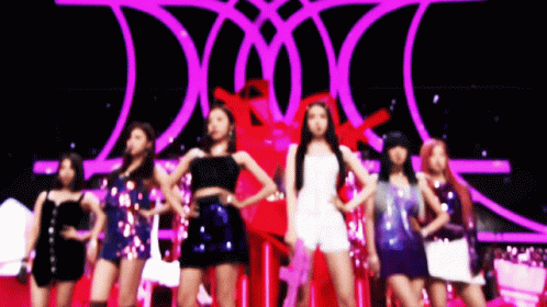 A Group Of Women Are Standing On A Stage With A Purple Background GIF