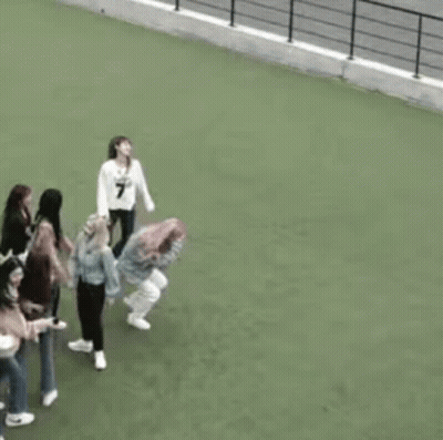 A Group Of Women Are Standing On Top Of A Green Field . GIF