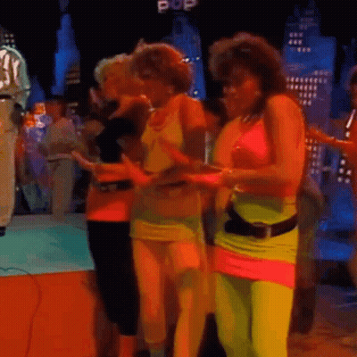 A Group Of Women Dancing In Front Of A Pop Sign GIF