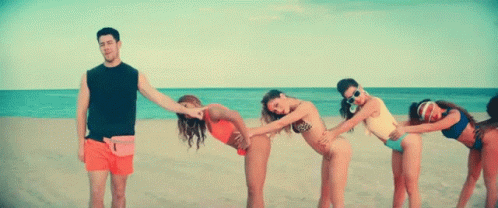 A Group Of Women In Bikinis Are Bending Over To Touch A Man 'S Butt On A Beach . GIF
