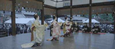 A Group Of Women In Kimonos Are Performing A Dance GIF